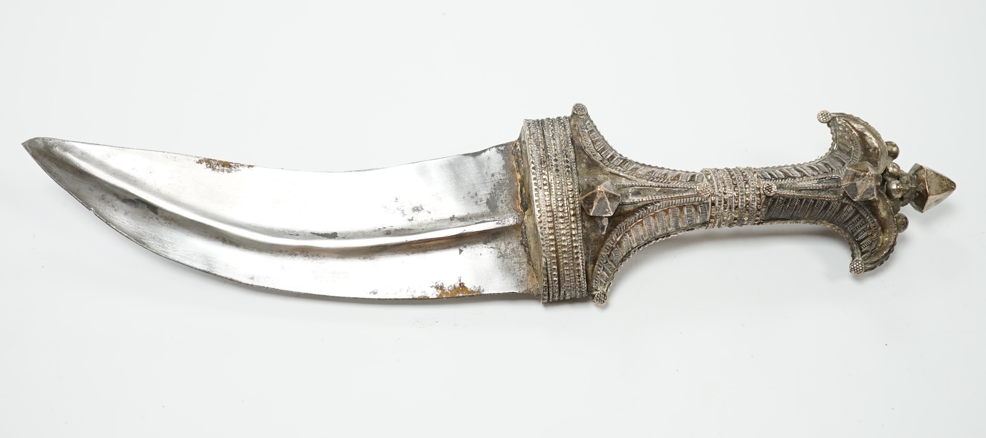 A composite Saudi dagger Jambiya c.1900, silver plated hilt, silver coloured metal sheath with engraved decoration. Condition - good, some wear